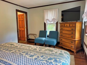 A bedroom with a bed, two chairs, a dresser, and a television. - Diamond Dreams, Very close to Dreams Park, Recent update, fire pit, large yard (Cooperstown)