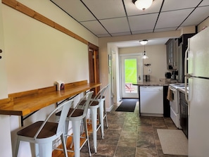 A kitchen with a wooden bar, white chairs, a refrigerator, and a stove. - Diamond Dreams, Very close to Dreams Park, Recent update, fire pit, large yard (Cooperstown)