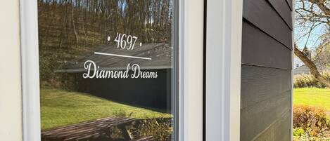 Número 4697 de una casa y el nombre 'Diamond Dreams' en un ventanal.