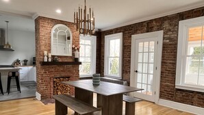 A kitchen with a brick wall, a large island, and a hanging light fixture. - Catskill Ski Hike Lake Pet Main St Pool (Catskill)