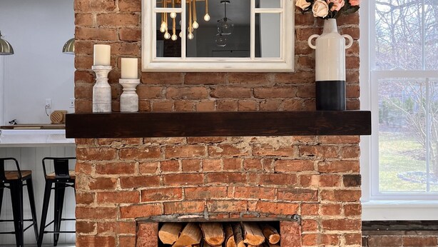 A brick fireplace with a mirror, candles, and a vase of flowers. - Catskill Ski Hike Lake Pet Main St Pool (Catskill)