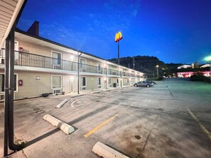 A motel with a McDonald's sign, a parking lot, and a building with multiple floors and balconies. - Economy Inn Sweetwater I-75 (Sweetwater)