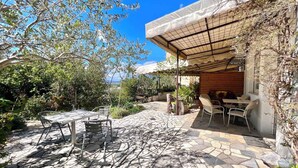 A patio with stone flooring, outdoor seating, and a pergola providing shade. - Holiday apartment with terrace and air conditioning (Dramalj)