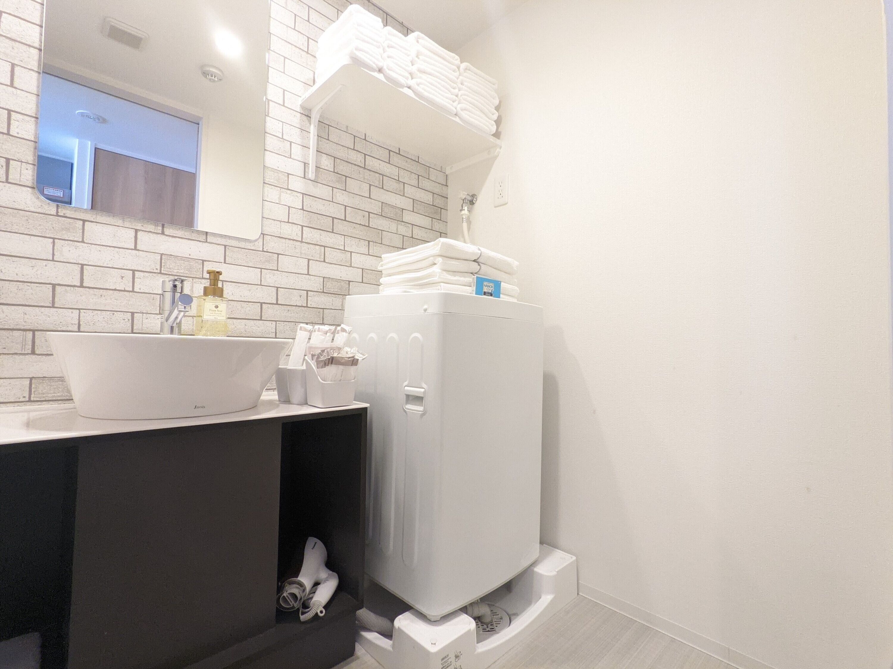 Een badkamer met een wit wastafel, een spiegel, een handdoekrek en een wit toilet.