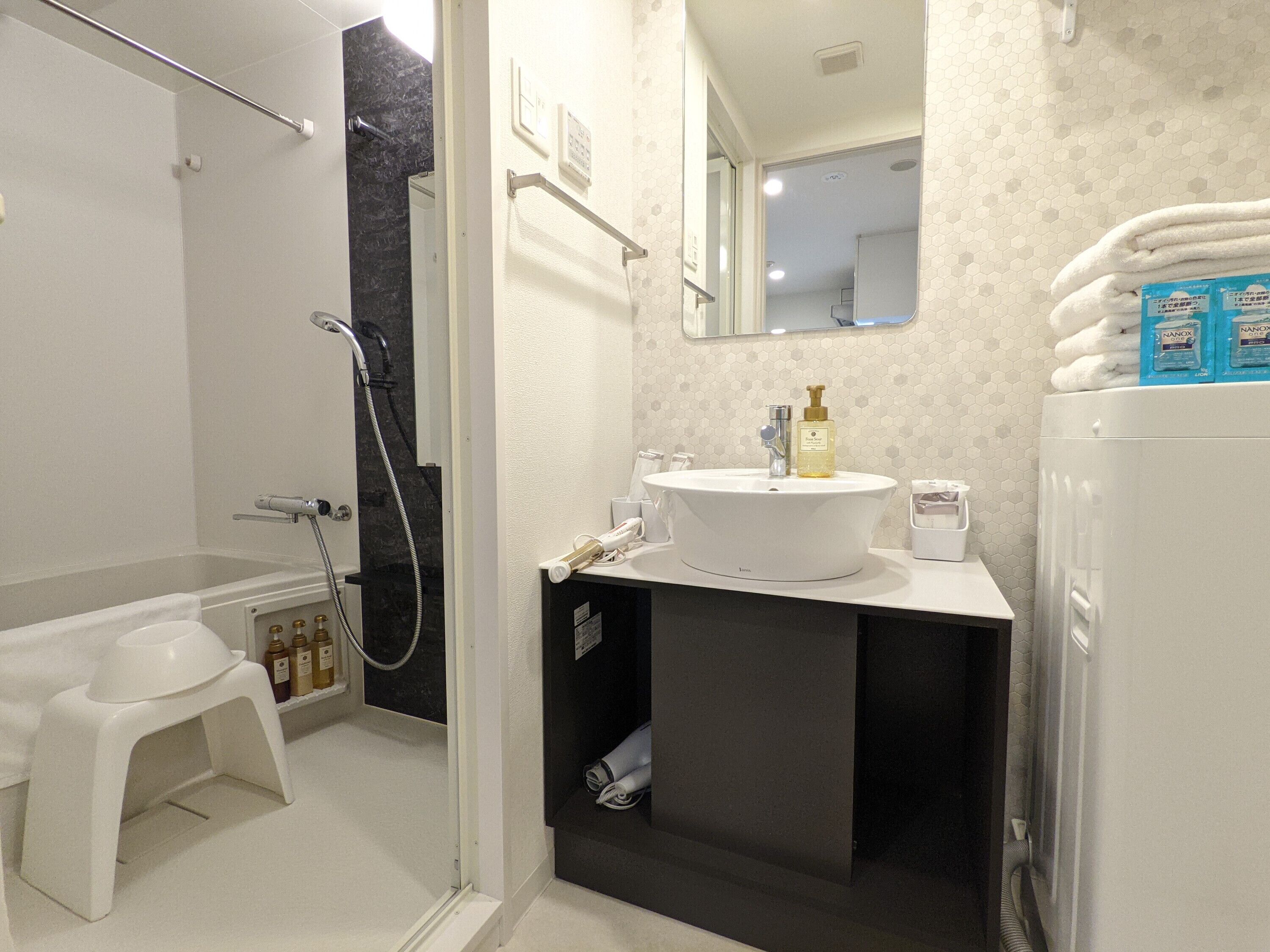 A bathroom with a bathtub, a sink with a mirror above it, and a shower area.