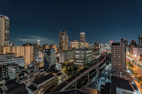 A cityscape at night with illuminated buildings, a train track, and a clear sky. - ESLEAD HOTEL OSAKA TSURUHASHI (Osaka)
