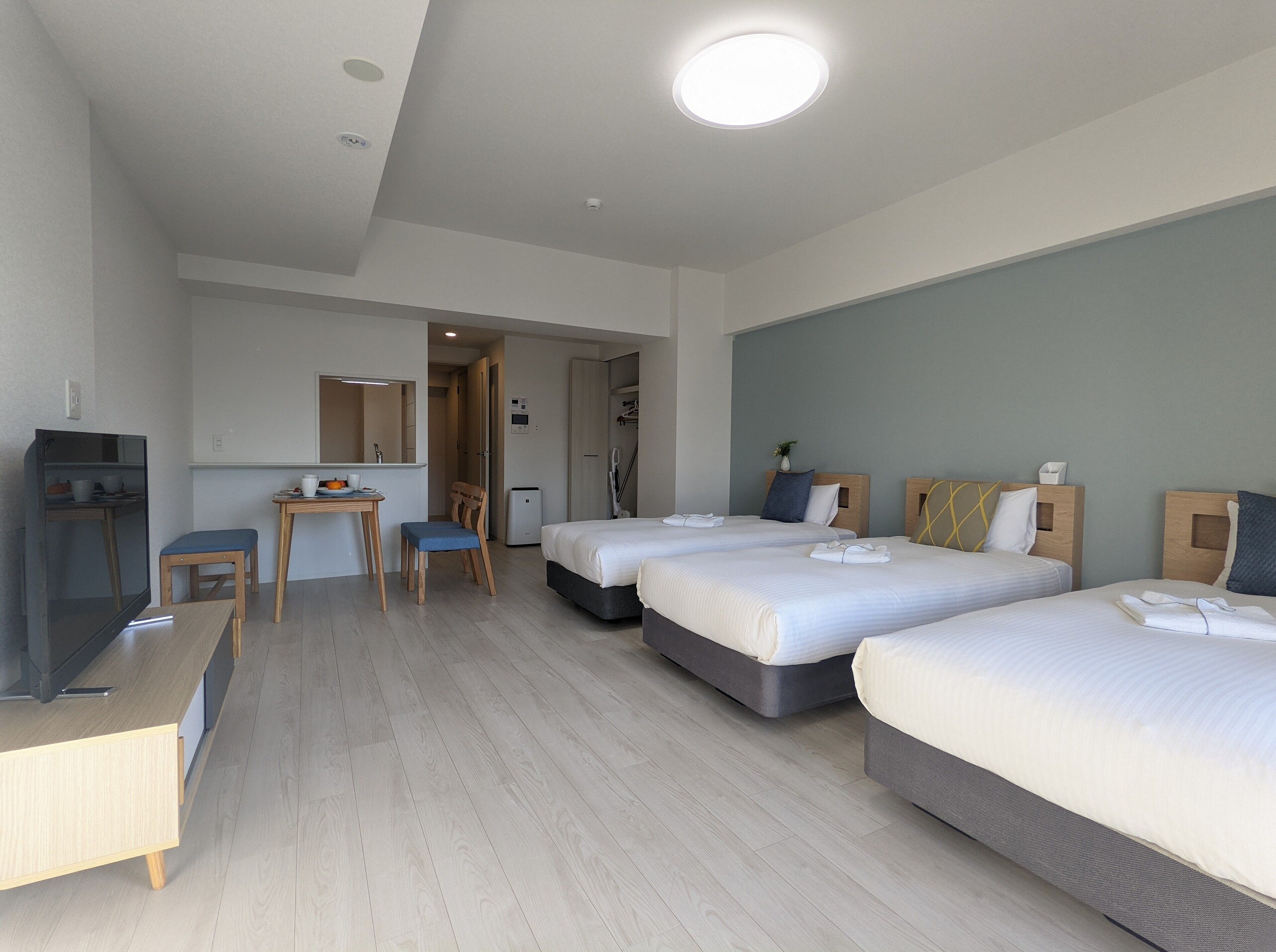 Habitación de hotel con dos camas, un escritorio, una silla, un televisor y un baño.