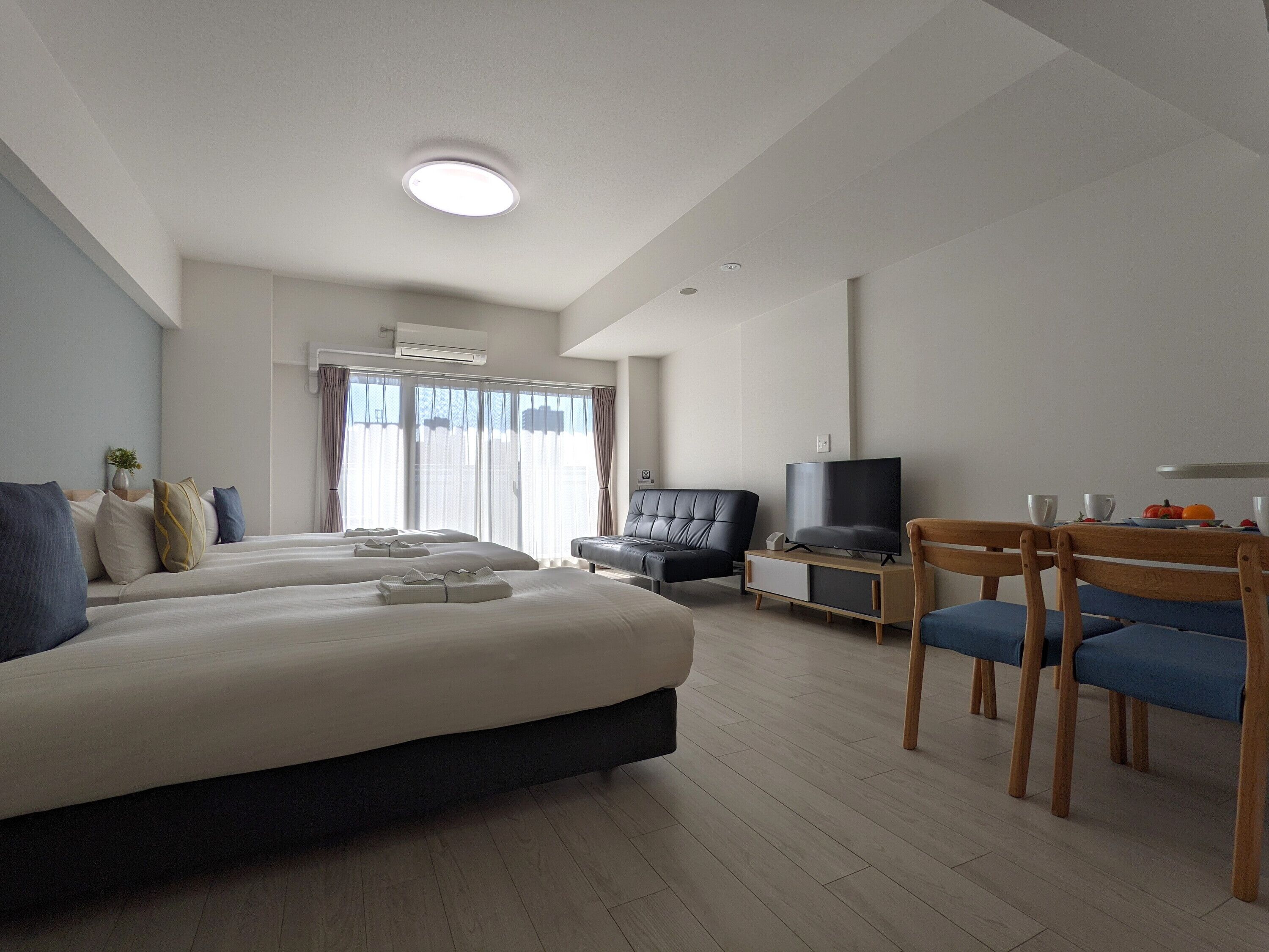 A hotel room with a large bed, a TV, a desk, and a chair.