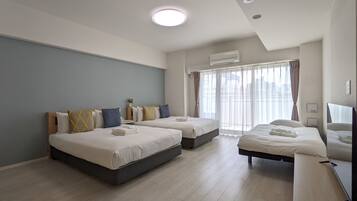 A modern hotel room with two beds, a large window with curtains, an air conditioning unit, and a flat-screen TV.
