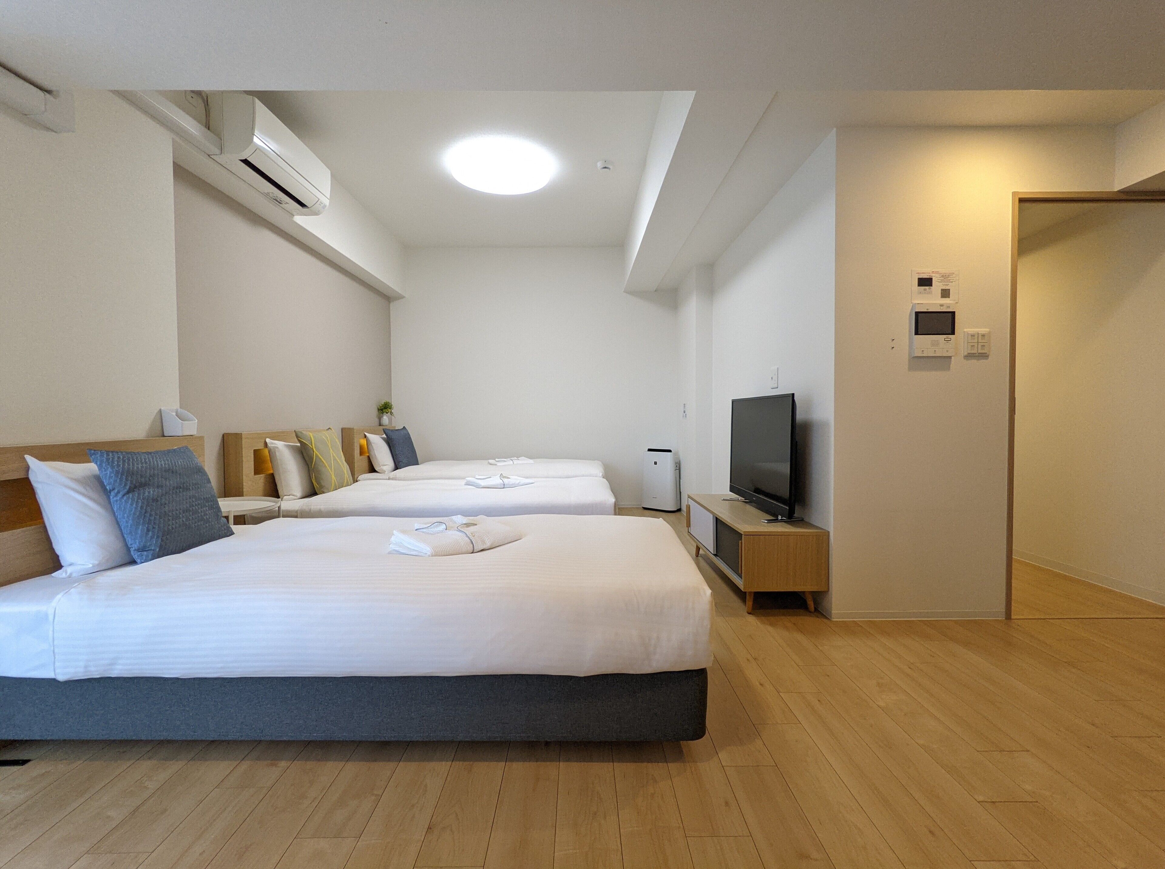 A hotel room with two beds, a TV, and a small desk.