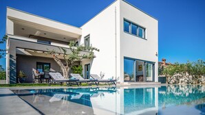 A modern two-story house with a swimming pool, outdoor seating, and a garden. - Beach front home in Pula (Pula)