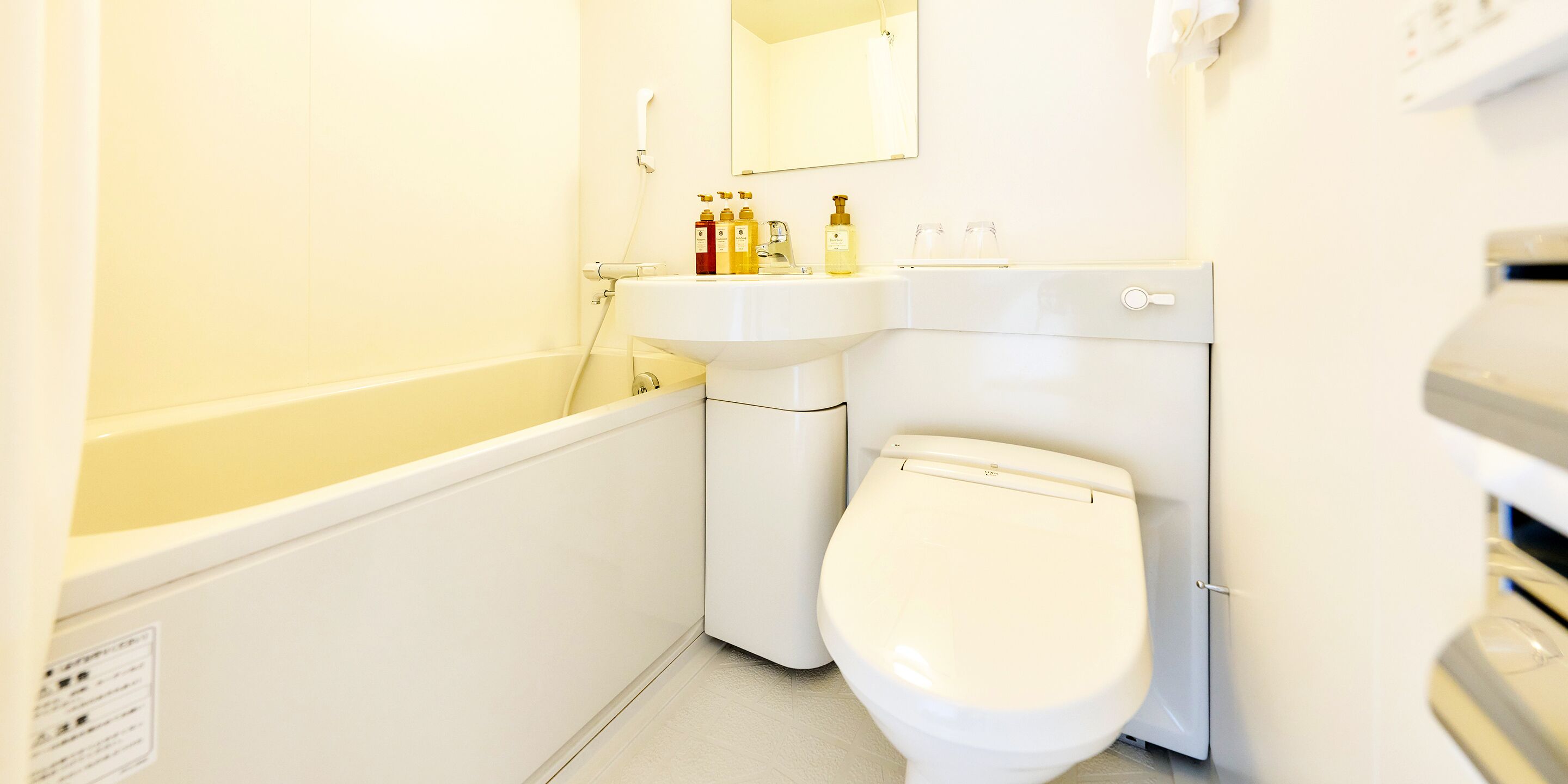 Un baño pequeño y blanco con inodoro, lavabo y espejo.