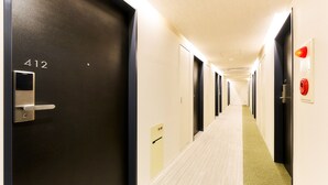 A hotel hallway with doors numbered 412, a fire alarm, and a carpeted floor.