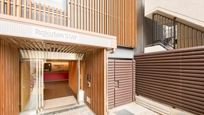 A modern building entrance with a sign reading "Rakuten Stay".