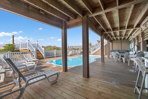 Relax by the pool with lounge chairs and a staircase leading to an upper level.