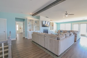 Relax in this inviting living room with a comfortable sofa, flat-screen TV, and ceiling fan.