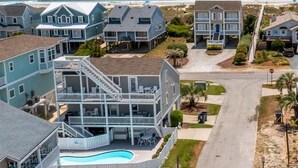 Una zona residenziale costiera con case affacciate sulla spiaggia, una piscina e una vista libera sull'oceano.