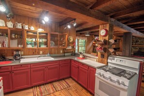 Kitchen features a stove, sink, and ample storage with a large island.