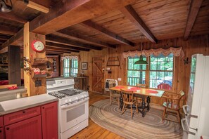 Cozy cabin-style kitchen with a large stove, dining table, and sink.