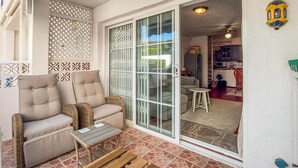 Un espace extérieur accueillant, aménagé avec des meubles en osier et un banc en bois.