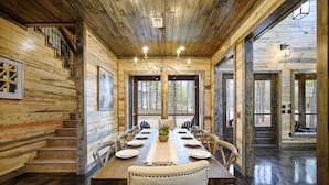 A wooden dining room with a long table, chairs, and a chandelier. - Sunlight Creek in Broken Bow, Sleeps 20! Creekside & Playset (Broken Bow)