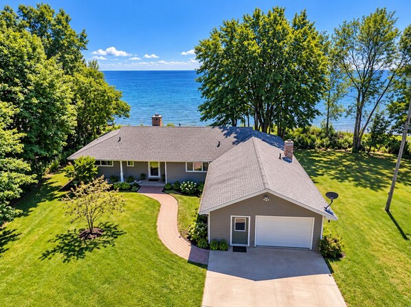 A single-story house with a garage, a driveway, and a well-maintained lawn.
