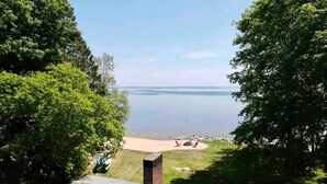 Udsigt over et søområde fra et boligområde med terrasse og udendørs møbler.