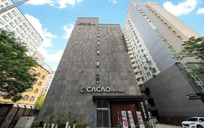 Un moderno edificio de hotel con un letrero llamativo para Cacao Hotel.