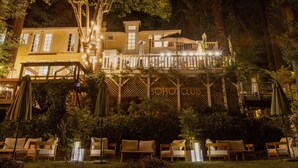 A two-story building with a balcony and outdoor seating area. - Boho Manor Resort - Room 24 (Monte Rio)