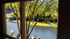 A view of a river with boats, trees, and a bridge in the background. - Boho Manor Resort - Room 24 (Monte Rio)
