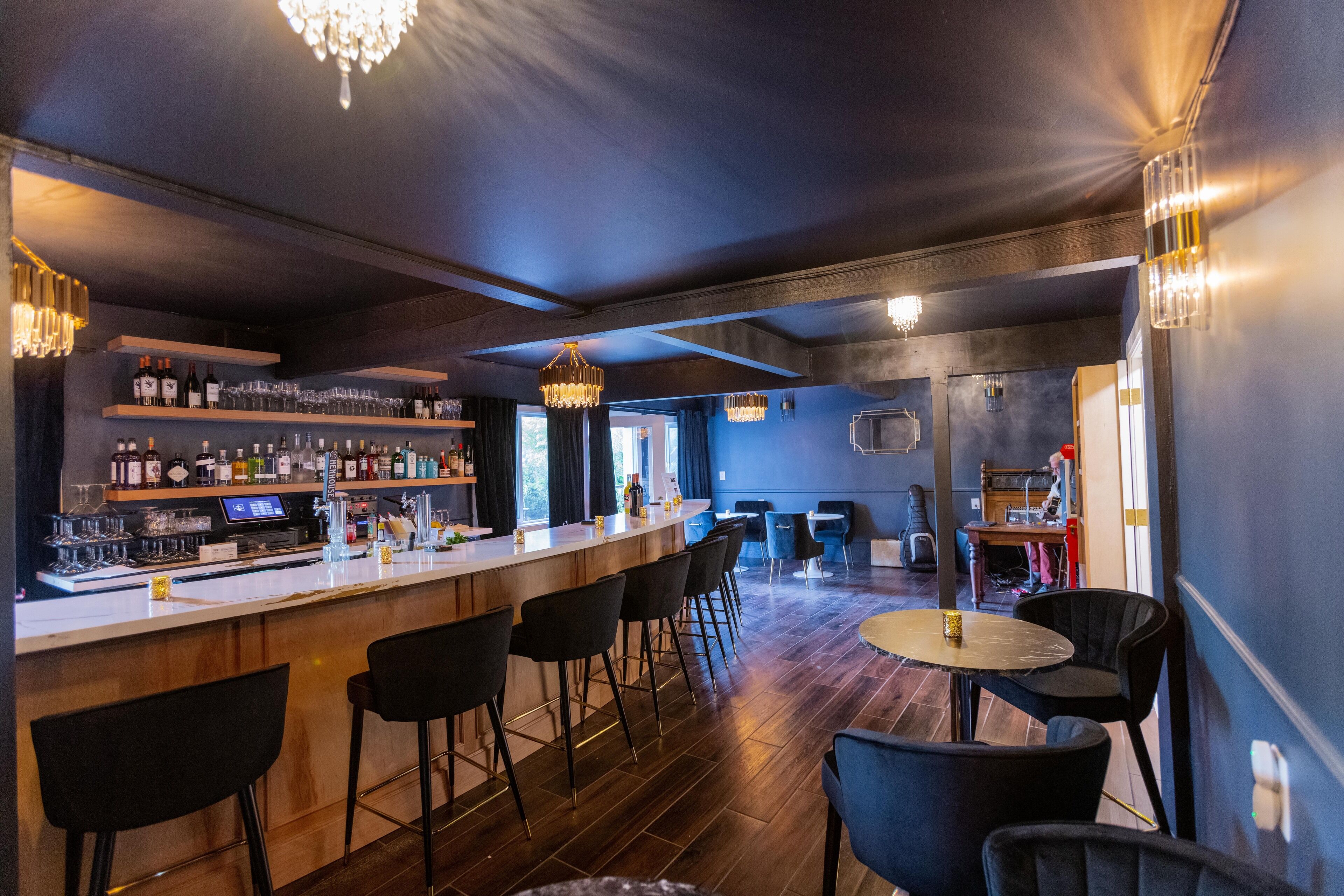 A bar area with a counter, bar stools, and a seating area with tables and chairs. - Boho Manor Resort - Room 24 (Monte Rio)