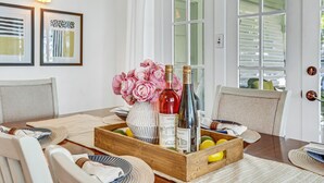 A dining table with a wooden tray containing wine bottles, lemons, and a vase of flowers. - A Huge, Calm, Relaxing, Beautiful Home close to Universal Studio (Pasadena)