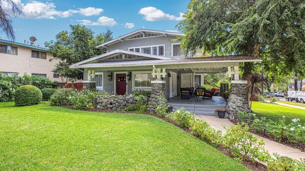 A two-story house with a covered porch, stone foundation, and a well-maintained lawn. - A Huge, Calm, Relaxing, Beautiful Home close to Universal Studio (Pasadena)