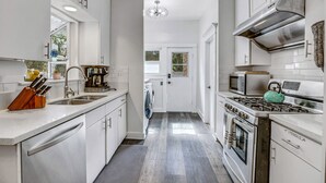 A modern kitchen with white cabinetry, stainless steel appliances, and a central island with a sink. - A Huge, Calm, Relaxing, Beautiful Home close to Universal Studio (Pasadena)