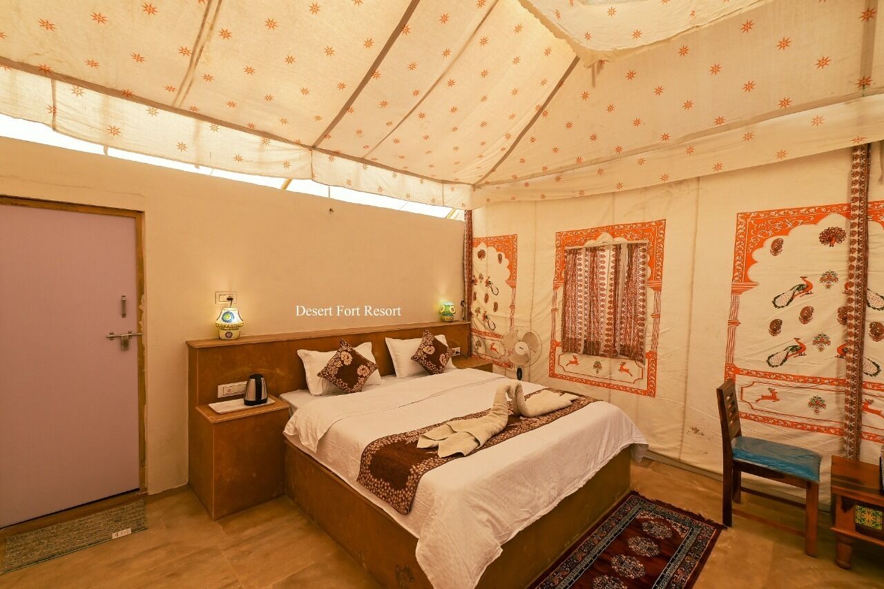 Habitación con cama, mesita de noche y una silla. El techo y las paredes presentan diseños tradicionales.