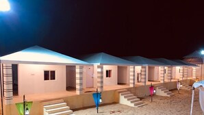 A row of connected hotel rooms with individual doorways and a central corridor.
