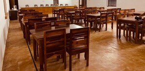 A large room with multiple wooden tables and chairs arranged in rows. - Desert Fort Resort (Jaisalmer)