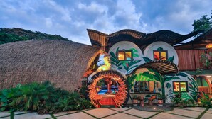 A unique building with a circular entrance, a thatched roof, and tropical plant decorations. - Saranda Boutique Hotel (Cahuita)