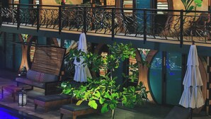 A modern building with a curved roof, outdoor seating, and a pool area. - Saranda Boutique Hotel (Cahuita)