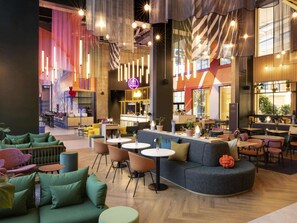 Relax in a stylish space with sofas, chairs, and round tables, plus a bar area and seating nook.