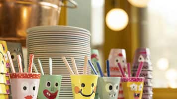 Tazas coloridas con caras y pajitas a rayas sobre una mesa.