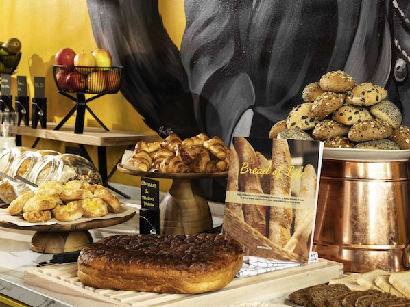 Baked goods and a book titled 'Bread of Life' are displayed on a counter in this inviting bakery setting.