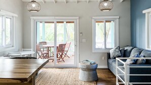Une pièce spacieuse avec une table à manger en bois, un canapé bleu et un ventilateur de plafond.