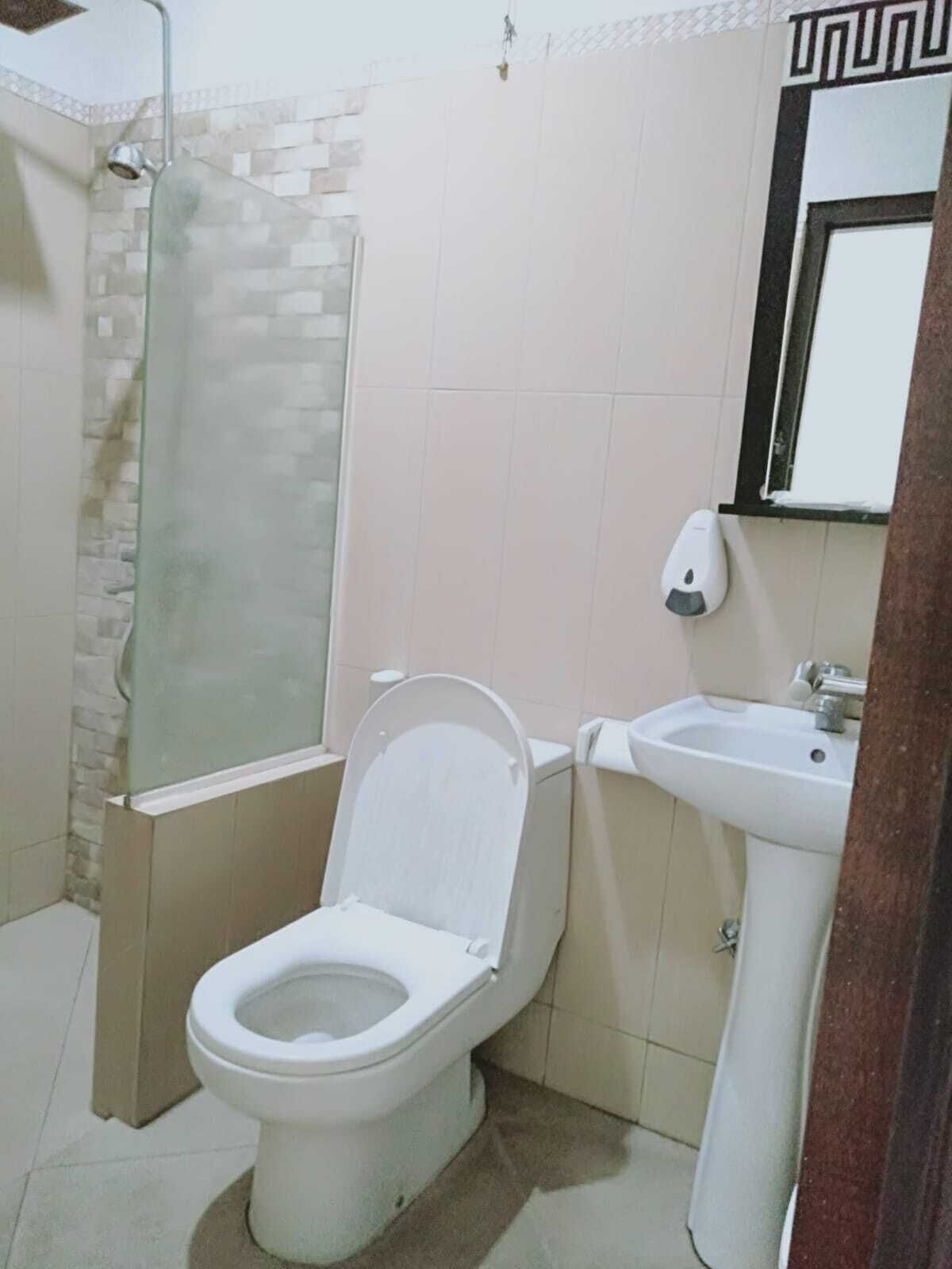 A bathroom with a toilet, a sink, and a shower.