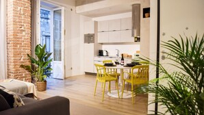 A modern apartment with a dining area, kitchen, and living room.