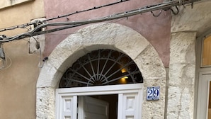A building entrance with a white door, a stone archway, and a number '29' sign.