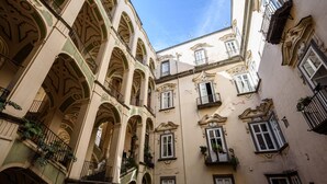 A narrow street with buildings featuring ornate facades and multiple balconies. - Palazzo Dello Spagnolo Suite (Naples)