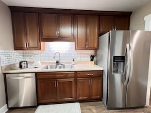Enjoy cooking in this well-equipped kitchen with a double sink, dishwasher, and stainless steel appliances.