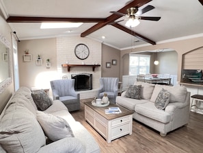 Relax in this inviting living room with a fireplace, comfortable seating, and a dining area.