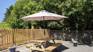 A picnic table with a canopy, surrounded by a wooden fence and potted plants. - An Rua (500m to Lahinch Beach), An Rua - 15 min walk to Lahinch Golf Club (Lahinch Road)